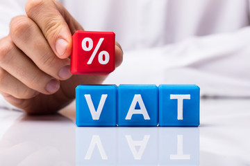 Person Placing Red Percentage Block Over Vat