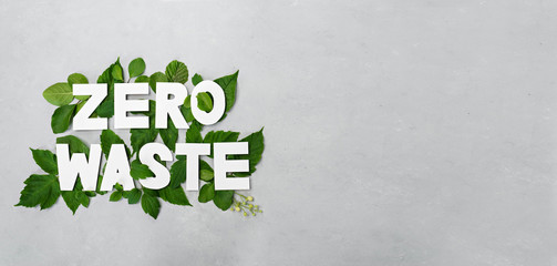 zero waste paper text witj green leaves on gray background - obrazy, fototapety, plakaty
