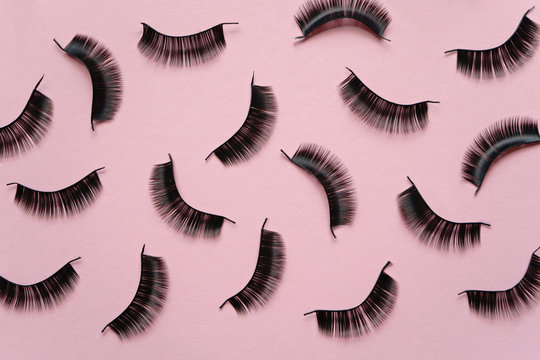 Black false lashes strips on pink background