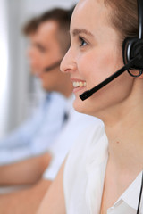 Call center. Focus on beautiful woman in headset