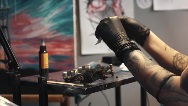 tattoo artist collects the tattoo machine. girl tattoo master prepares a rotary tattoo machine gun for drawing a drawing on the skin