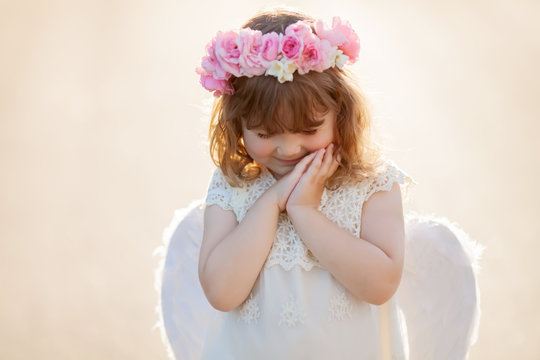 Portrait of beautiful little Angel girl with floral wreath