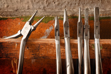 different pliers from a goldsmith, tools on the jewelry workplace, selected focus