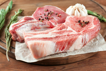 Fresh raw pork ribs on wooden board, closeup