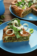 Piece of tasty pie with spinach on plate