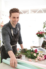 Male florist creating beautiful bouquet in flower shop