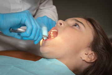 Naklejka premium background. girl at the reception at the dentist. preparation of work with a cofferdam. professional dentistry