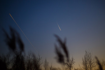 Obraz premium Airplane flying in the sky among clouds and sunset