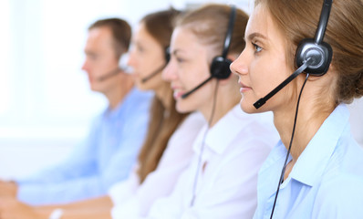 Call center operator in headset while consulting client. Telemarketing or phone sales