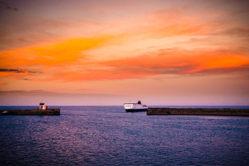 Cruise ship vessel approaching port at sunset  