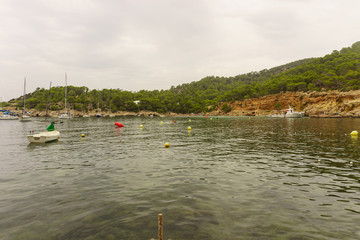 Benirras beach, Ibiza, Spain - 27 August, 2017: boats sailing on the beaches of ibiza with tourists enjoying their holidays