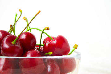 Cherries in glass dish. Cherry on wood and white background. - healthy eating and food concept
