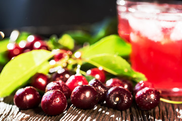 Fresh cherries and ice cherry fruit drink on wood