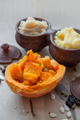 Vegetarian wheat porridge with large bright orange pieces of juicy roasted pumpkin