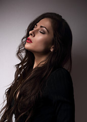 Thinking emotion beautiful woman profile with closed eyes, red lipstick and long hair on dark background. Closeup portrait