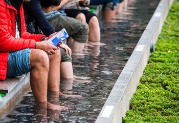 HAKONE, JAPAN - NOVEMBER 5, 2017: People put their feet in a hot hydrogen sulphide source in the...