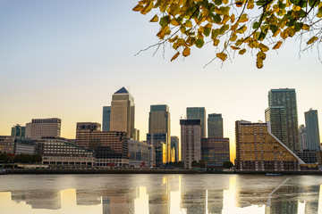Panorama of Canary Wharf business district with water reflection at sunset