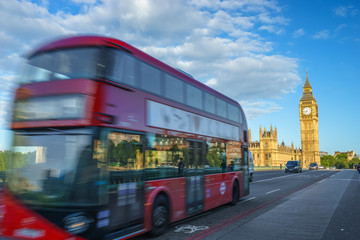 Obraz na płótnie Canvas Blurry red bus in motion and Big Ben in the background in London. England