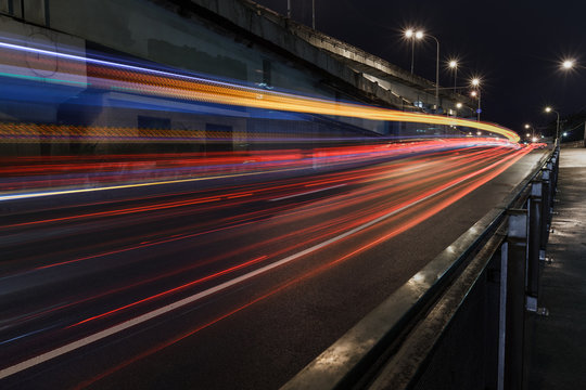 Time-lapse Photograph of Light Trails caused by cars driving along a road in the city.