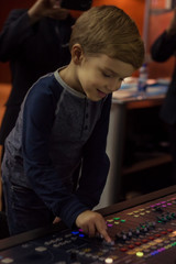 Happy kid at sound mixing desk in a studio.