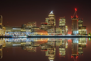 Fototapeta na wymiar Canary Wharf business district with water reflection and christmas lights at night