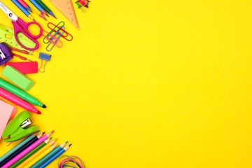 School supplies side border against a bright yellow paper background