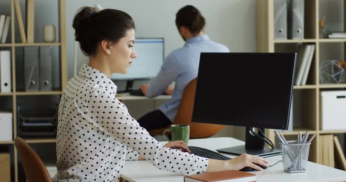 Side view on the angry nervous woman coping with a broken computer with an error writing on its screen, typing and shaking it. Inside.