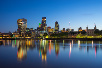 Skyscrapers of London financial district and Tower of London at blue hour 