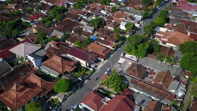 Flying over traditional rooftops and modern streets in Yogyakarta city, Indonesia