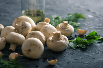 White Champions, spices and ingredients on the dark kitchen table. The concept of cooking mushroom dishes