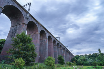 Fototapeta premium Old railway viaduct viewed with cloudy sky. Welwyn Garden City, England