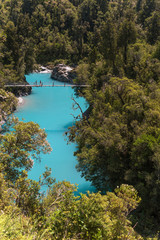 Bright blue, glacier fed Hokitika River flowing through the forest clad Hokitika Gorge, West Coast, New Zealand.