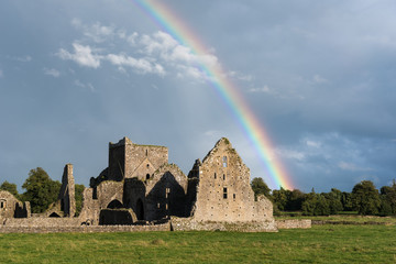 Hore Abbey under a rainbow and dark rainclouds. The Abbey is a ruined cistercian monastery near the...