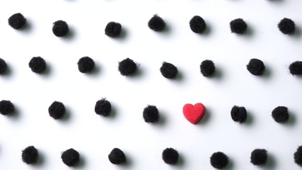 Little red heart in black pom poms polka dot on white background © Nan Natrada