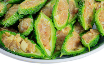 Bitter gourd pile with stuffed hack pork and garlic black pepper ingredient in plate on white background. vegetable herb Nourish the health body. Thai food