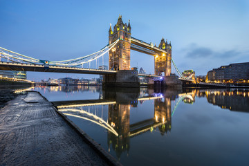 Fototapeta na wymiar Tower Bridge with blue sky and with beautiful water reflection during low tide in London, England