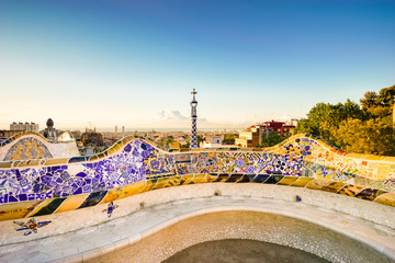Barcelona at sunrise viewed from summer park Guell. Park was built from 1900 to 1914 and was officially opened as a public park in 1926. In 1984, UNESCO declared the park a World Heritage Site