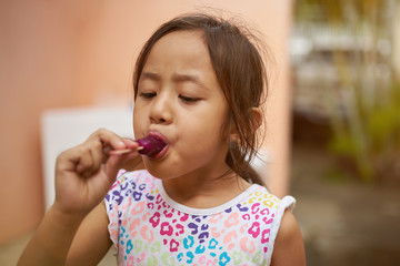 Small asian girl suck ice cream