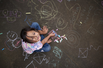 Asian small girl with chalk - obrazy, fototapety, plakaty