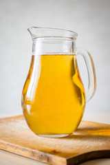 White Georgian wine in big glass pitcher as part and ingredient of chakapuli traditional meat food with cilantro.