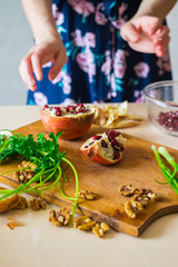 Woman hands peeling and carving pomegranate. Sweet asian fruit. Raw vegan vegetarian healthy food