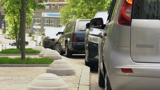 Driver throwing trash out of car window, contamination in city, dirty sidewalks