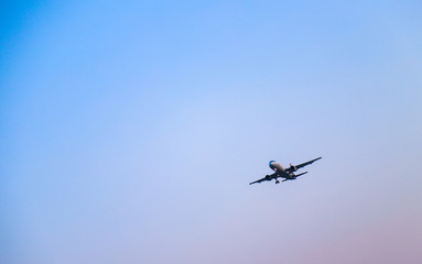 An aeroplane is flying in the evening.