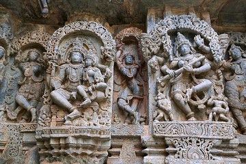 Ornate wall panel reliefs depicting from left Shiva-Parvati and dancing Sarswati, Kedareshwara temple, Halebidu, Karnataka