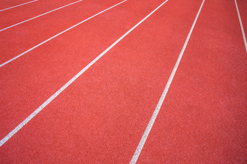 White lines of stadium and texture of running racetrack red rubber racetracks in outdoor stadium are 8 track and green grass field,empty athletics stadium with track.