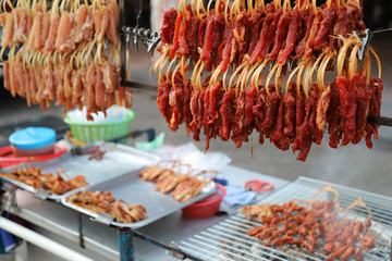 Closeup of grilled meat on vendor stand, famous street barbecue in Asia.