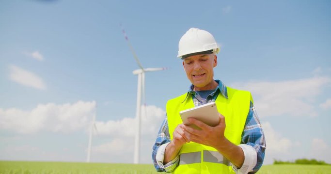 Engineer using digital tablet on Wind Turbine Farm