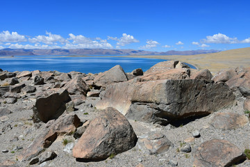 China. Great lakes of Tibet. Stones with mantras on the store of Lake Teri Tashi Namtso in sunny summer day