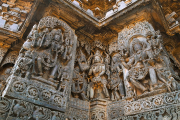 Fototapeta na wymiar Ornate wall panel reliefs depicting Hindu deities, west side, Hoysaleshwara temple, Halebidu, Karnataka