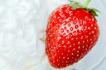 large ripe strawberry lies on air cream
